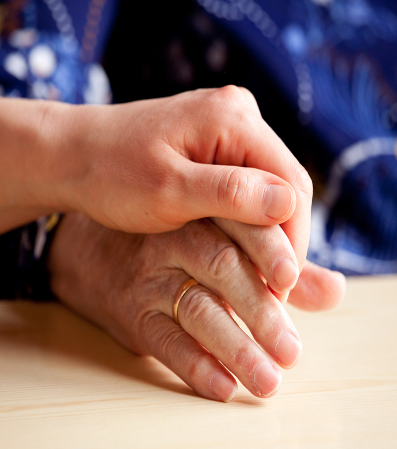 A young hand comforts and elderly hand